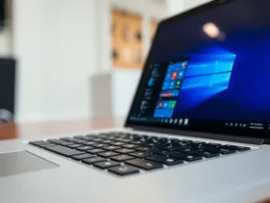 Nowoczesne stanowisko pracy z laptopem wyświetlającym panel sklepu internetowego i wykresy sprzedaży dropshippingowej.
